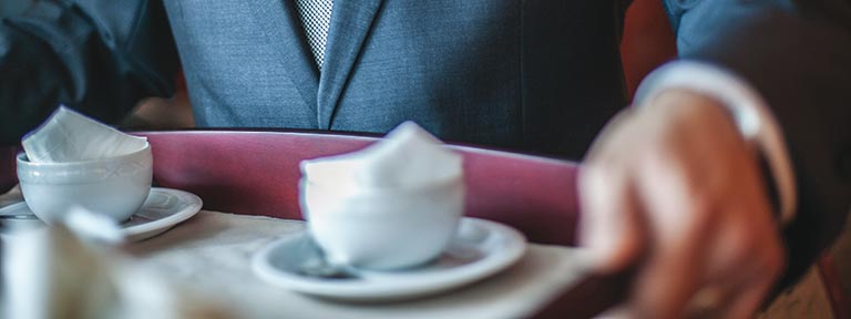 A waiter carrying coffee cup